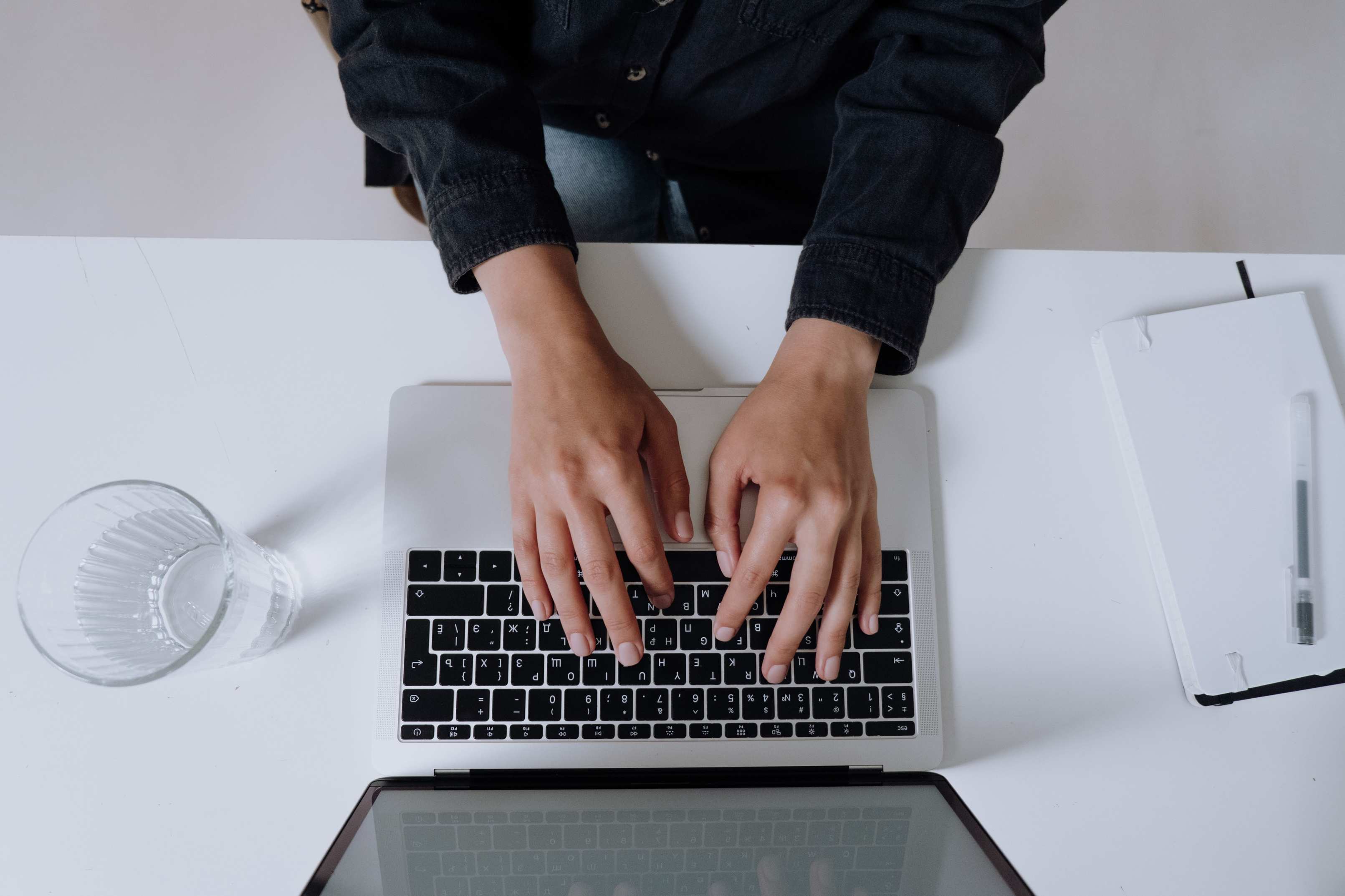 Close-up view of hands typing on a laptop keyboard, focusing on digital work